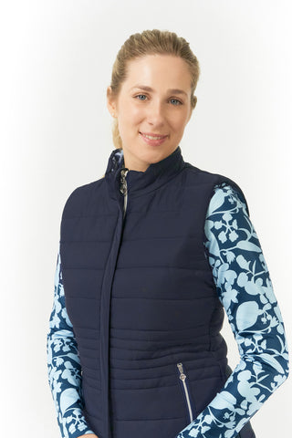 Pure Golf Eve reversible ladies gilet for golf is insulated, winter-weight, patterned and reversible. It has been Insulated for warmth without being bulky. One side features intricate Midnight Rose floral prints in navy and powder blue, while the other offers a classic plain navy option for versatility of wear. It has pockets on both sides and two-way zippers. The flattering quilting style and fit enhances your silhouette. 