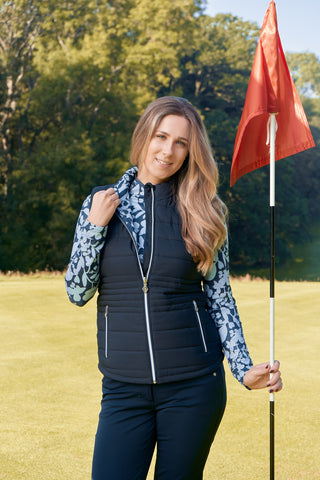 Pure Golf Eve reversible ladies gilet for golf is insulated, winter-weight, patterned and reversible. It has been Insulated for warmth without being bulky. One side features intricate Midnight Rose floral prints in navy and powder blue, while the other offers a classic plain navy option for versatility of wear. It has pockets on both sides and two-way zippers. The flattering quilting style and fit enhances your silhouette. 