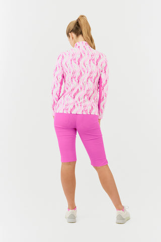 The Pure Golf Balance long-sleeve ladies' golf zip top in Rose Water, shown in a back model shot, features layers of delicate petals in varying shades of pink. With a regular fit, it offers 4-way stretch for comfort across all body types. The mock neck collar adds a sleek, modern touch, while the mesh sleeve panels enhance breathability. Made from 95% Polyester and 5% Spandex, the top is anti-crease, anti-static, quick-drying, and provides UPF 50+ sun protection. Paired with Azalea Pink Bermuda Shorts. 