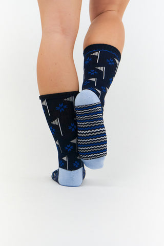 Ladies 3 pair pack in Navy, Grey and Black crew golf socks have a trendy golf flag design with lurex stripe detailing on the sole. Made from a soft, stretchy cotton blend fabric allowing breathability, with a cushioned sole, compression fit and Rib cuff for a snug fit. They are suited to UK sizes between 4 and 7. 85% Cotton, 13% Polyester, 2% Elastane.