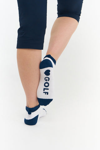 3 pair pack of ankle ladies golf socks, one pair in white with Navy detail on the sole and two pairs in white with Navy heals, toe, cuff and the word golf along the sole. With coordinating colour pom pom on the heel to help the socks hold their position. Made from a soft, stretchy cotton blend fabric allowing breathability, with a cushioned sole and compression fit. They are suited to UK sizes between 4 and 7. 85% Cotton, 13% Polyester, 2% Elastane.