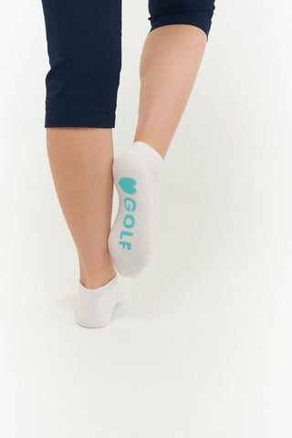 White ladies trainer golf sock, 3 pack with 2 stripped Aqua pairs and one plain white pair with a cushioned sole and compression fit. The lower cut around the ankle makes them less visible when worn. An attractive stripe design with the word golf on the sole. Made from a soft, stretchy cotton blend fabric allows breathability. They are suited to UK sizes between 4 and 7. 85% Cotton, 13% Polyester, 2% Elastane.