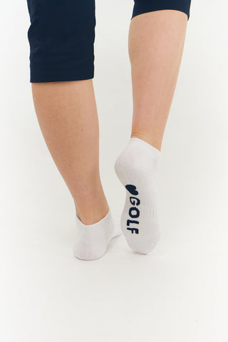 White ladies trainer golf sock, 3 pack with 2 stripped Navy pairs and one plain white pair with the word "golf" on the sole, also with a cushioned sole and compression fit. The lower cut around the ankle makes them less visible when worn. Made from a soft, stretchy cotton blend fabric allows breathability. They are suited to UK sizes between 4 and 7. 85% Cotton, 13% Polyester, 2% Elastane.