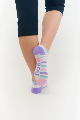 White ladies trainer golf sock, 3 pack with 2 stripped purple, pink and blue pairs and one plain white pair with the word "golf" on the sole, also with a cushioned sole and compression fit. The lower cut around the ankle makes them less visible when worn. Made from a soft, stretchy cotton blend fabric allows breathability. They are suited to UK sizes between 4 and 7. 85% Cotton, 13% Polyester, 2% Elastane.