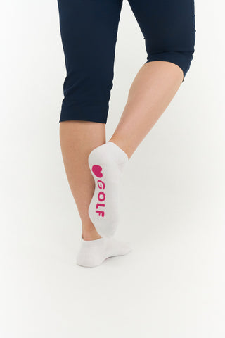 White ladies trainer golf sock, 3 pack with 2 stripped Pink pairs and one plain white pair with the word "golf" on the sole, also with a cushioned sole and compression fit. The lower cut around the ankle makes them less visible when worn. Made from a soft, stretchy cotton blend fabric allows breathability. They are suited to UK sizes between 4 and 7. 85% Cotton, 13% Polyester, 2% Elastane.