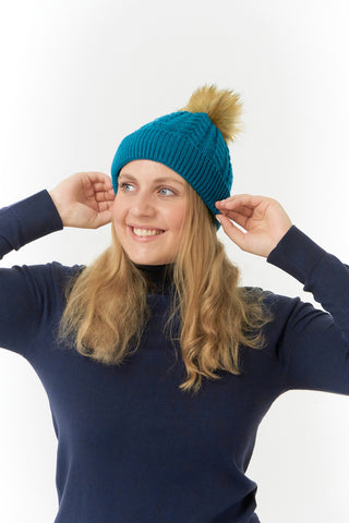 Teal ladies golf hat In an attractive cable knit design. This hat has three layers - an inner waterproof layer plus a soft fleece lining which makes it warm and comfortable. Detachable faux fur bobble in natural colours.